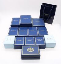 A collection of fourteen boxed Halcyon Days enamelled boxes to include; Born to Shop, With love from