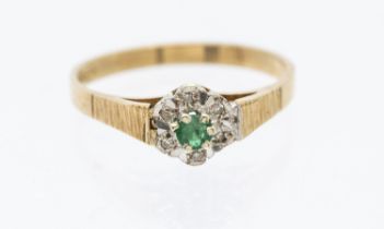 An emerald and diamond 9ct gold cluster ring with box - set to the center with a round emerald