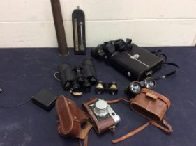 A collection of vintage binoculars including Theatre along with vintage Russian camera and WW2 shell
