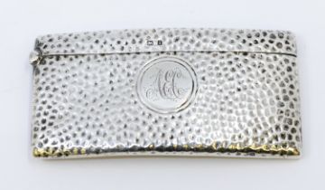 An Edwardian planished silver card case, of curved rectangular form, central initialled cartouche,