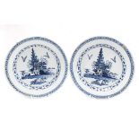 A pair of 18th century Delftware plates, painted in blue, diameter 23.2cm. (2) Condition note:
