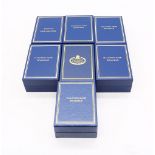 A collection of seven boxed Halcyon Days enamelled boxes to include; Just to say I love you, A