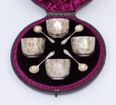 A cased Victorian silver condiment set consisting of four matching salt cellars of bucket shape with