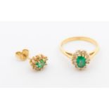 A diamond and emerald cluster 14ct gold cluster ring, comprising an oval mixed cut emerald within