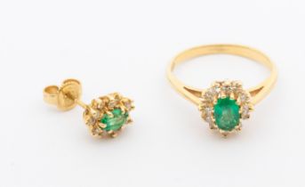 A diamond and emerald cluster 14ct gold cluster ring, comprising an oval mixed cut emerald within