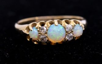An opal and diamond 18ct gold ring, set with round opals with small diamond accents, width approx