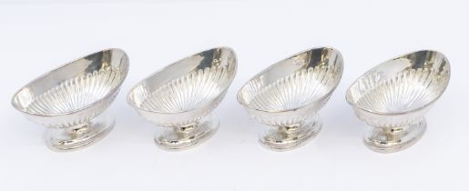 Four matching Victorian silver salt cellars, of curved oval form with gadrooned bodies, on oval