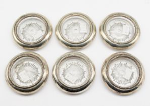 A set of six 20th century silver and moulded glass coasters, all with ribbed designed rims and