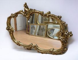 A very large 20th century reproduction wall mirror, of ornate gilt design. Approx. 170cm long.