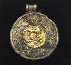 Gold clad pendant depicting helmeted bust in the centre surrounded by a silver embossed border