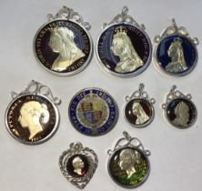 9 mixed enamelled British silver coins mounted as pendants & a brooch, George II - Victoria