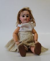 An early 20th century French Jumeau-type bisque head doll. Head mould number 7. Open brown eyes