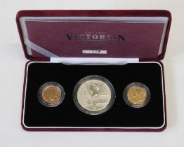 A cased Victorian Centenary Collection of three coins, a five pound coin, a 2001 sovereign and a