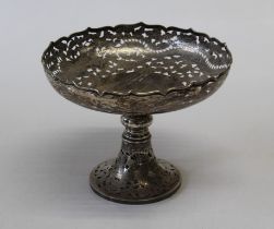 An early 20th century Chinese export silver tazza, pierce decorated with dragons and clouds, knop