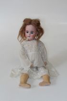 An Armand Marseille bisque head doll. Fixed blue eyes, open mouth with composition body and limbs.