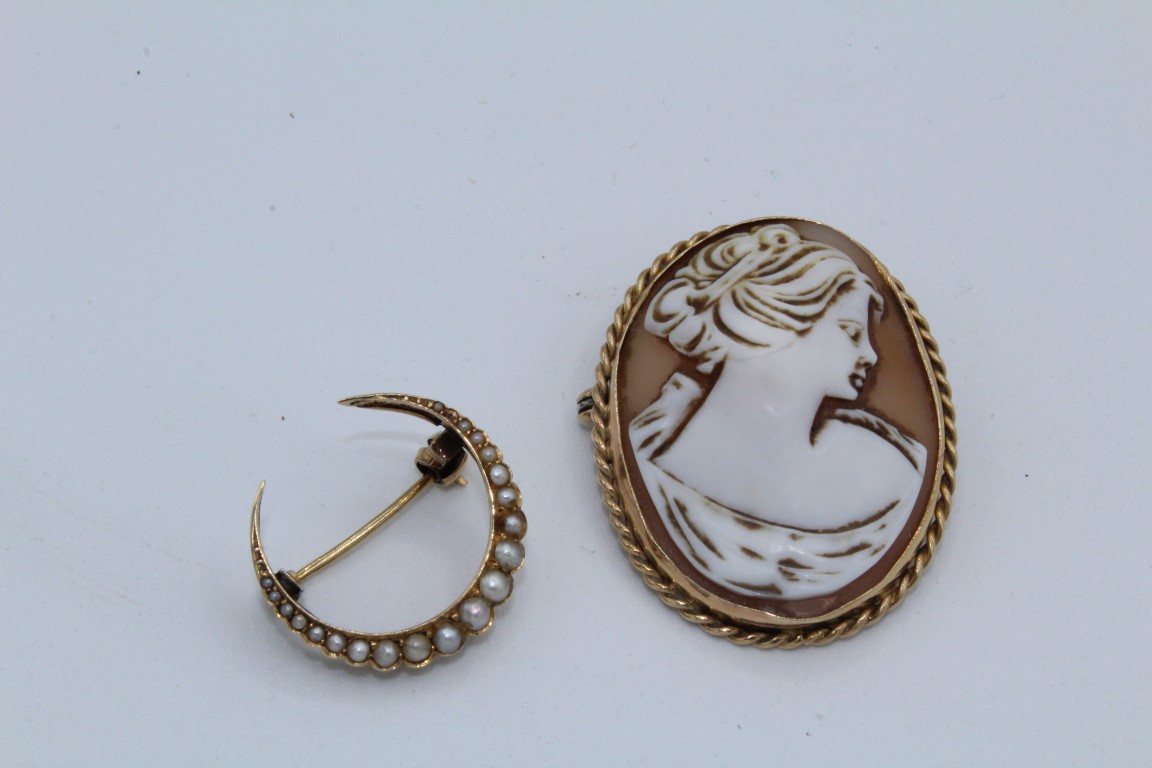 A seed pearl crescent brooch along with a 9ct gold shell cameo brooch. The crescent is stamped "