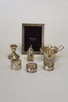A collection of hallmarked sterling silver comprising a pepperette, three napkin rings, a small