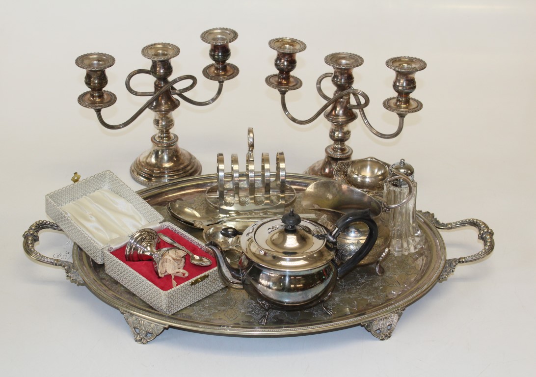 An early 20th century EPNS oval twin handled tray, a pair of three light table candlesticks, a