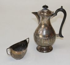 William Hutton and Sons Ltd, a George V silver hot water pot, of demi-reeded form, with ebonized