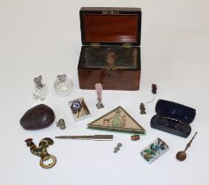 A wooden box containing a variety of collectables to include a hand beaded glass and cut steel