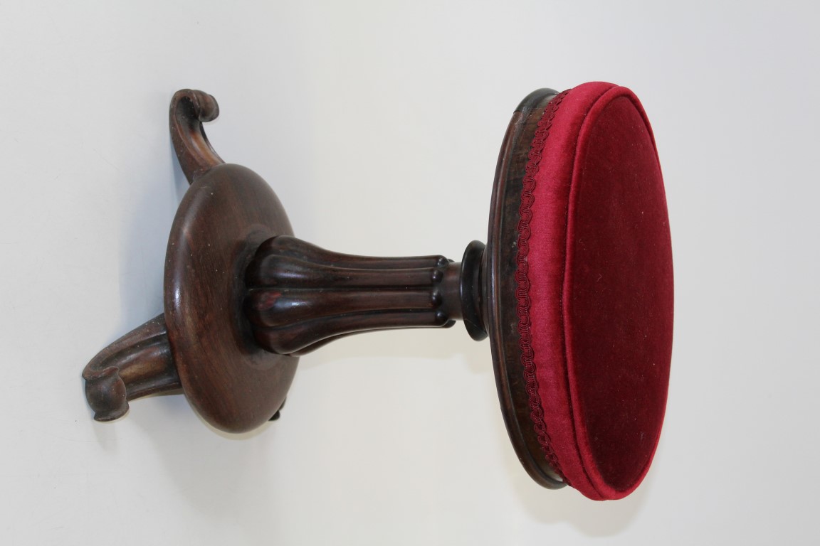 A Victorian rosewood stool, the circular overstuffed seat raised on a shaped fluted column and