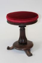 A Victorian rosewood stool, the circular overstuffed seat raised on a shaped fluted column and