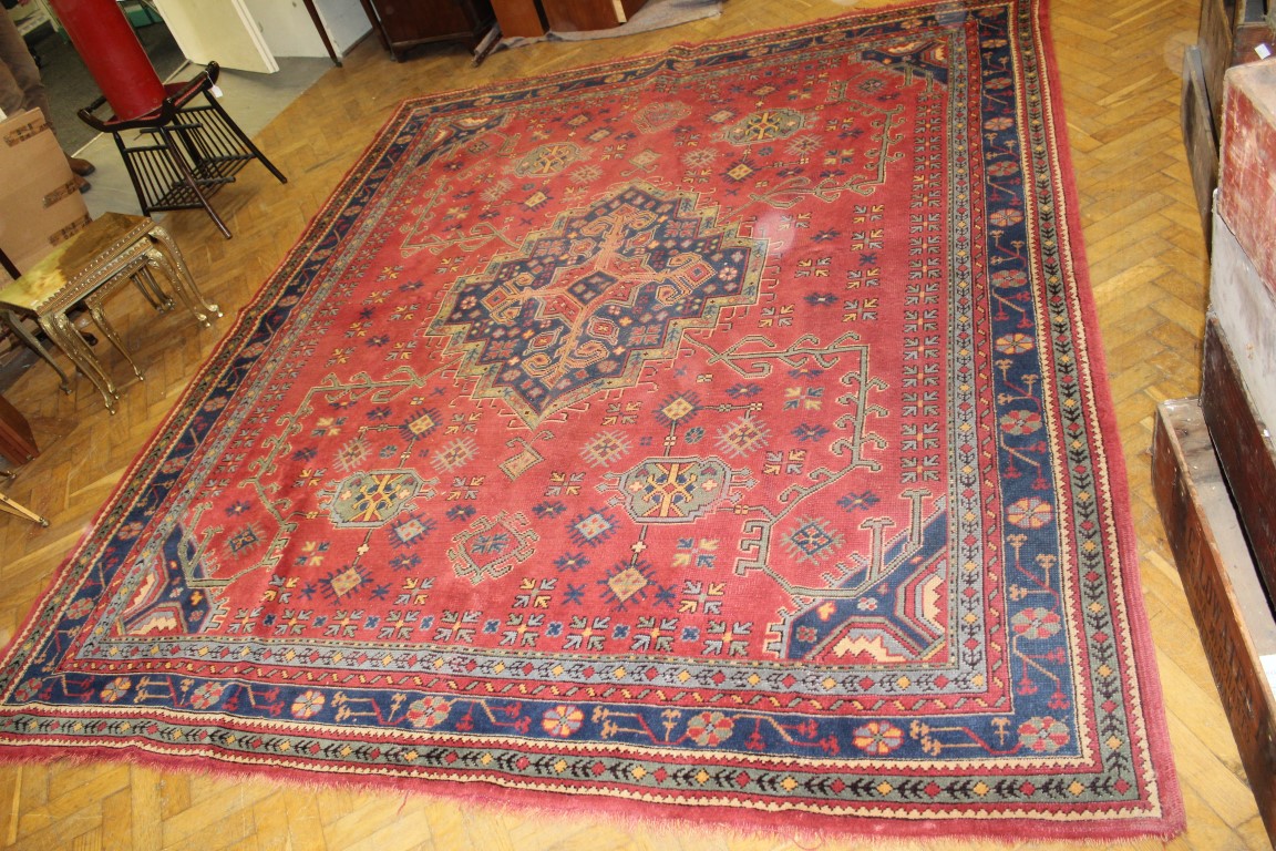 An Ushak carpet, the brick field having a central indigo medallion enclosed by an indigo border, 325