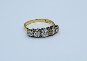 A five stone diamond ring set with five graduated round old mine cut diamonds, to an estimated
