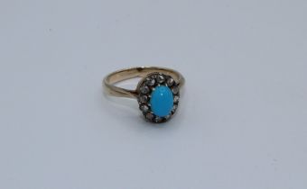 An unmarked Edwardian gold ring, set with turquoise, in a border of old cut diamonds. Size M,