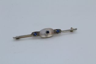 An Art Deco moonstone, sapphire and diamond bar brooch. Featuring a frosted moonstone cabochon, with