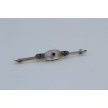 An Art Deco moonstone, sapphire and diamond bar brooch. Featuring a frosted moonstone cabochon, with