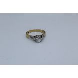 An 18ct diamond solitaire ring. Set with a principal stone of an estimated 0.65 carats. Shoulders