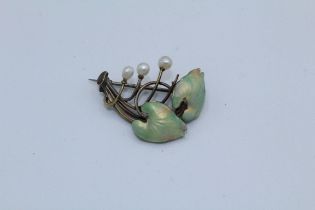 An Art Nouveau enamelled leaf brooch, featuring prongs terminated by baroque pearls (one prong