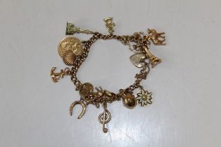 A 9ct gold charm bracelet with a heart padlock clasp. To include an Edward VII 1902 half