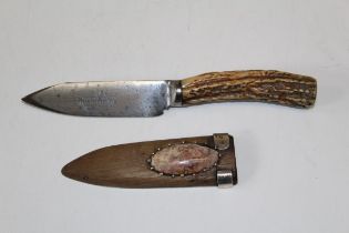 A small hand crafted Skean Dhu, with stag horn handle in a white metal, agate set wood scabbard.