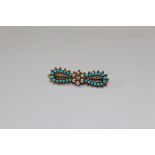 A Victorian turquoise, seed pearl and diamond archaeological revival style bow brooch. Set with