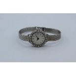 A diamond set white metal early 20th century mechanical ladies wristwatch with baton markers on a