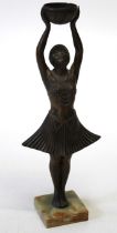 An Art Deco period cast bronze patinated spelter figure of a dancing girl holding a bowl above her