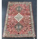 A 20th century Persian wool rug, woven with a triple pole medallion, on a salmon/ cream ground,