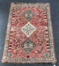 A 20th century Persian wool rug, woven with a triple pole medallion, on a salmon/ cream ground,