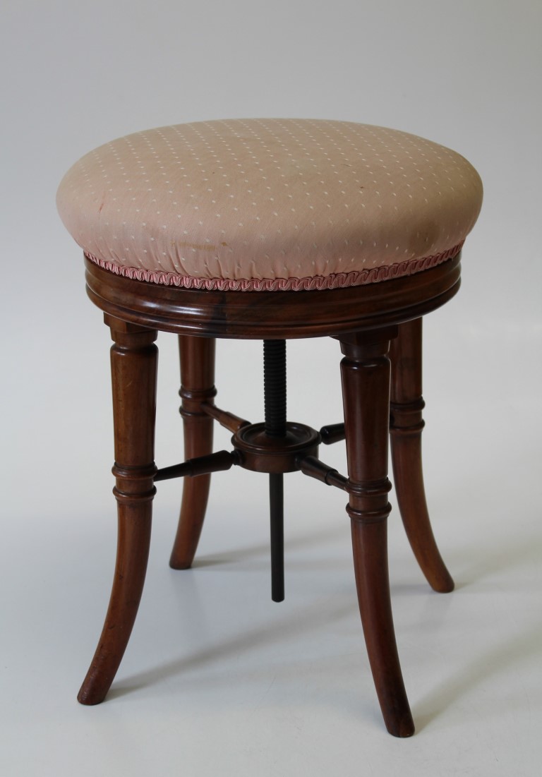 A good Victorian mahogany adjustable piano stool the circular overstuffed seat raised on swept legs,