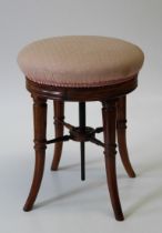 A good Victorian mahogany adjustable piano stool the circular overstuffed seat raised on swept legs,