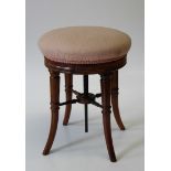 A good Victorian mahogany adjustable piano stool the circular overstuffed seat raised on swept legs,