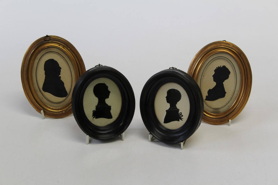 A pair of 19th century cut-card silhouette portrait miniatures, a lady and gentleman, each in oval