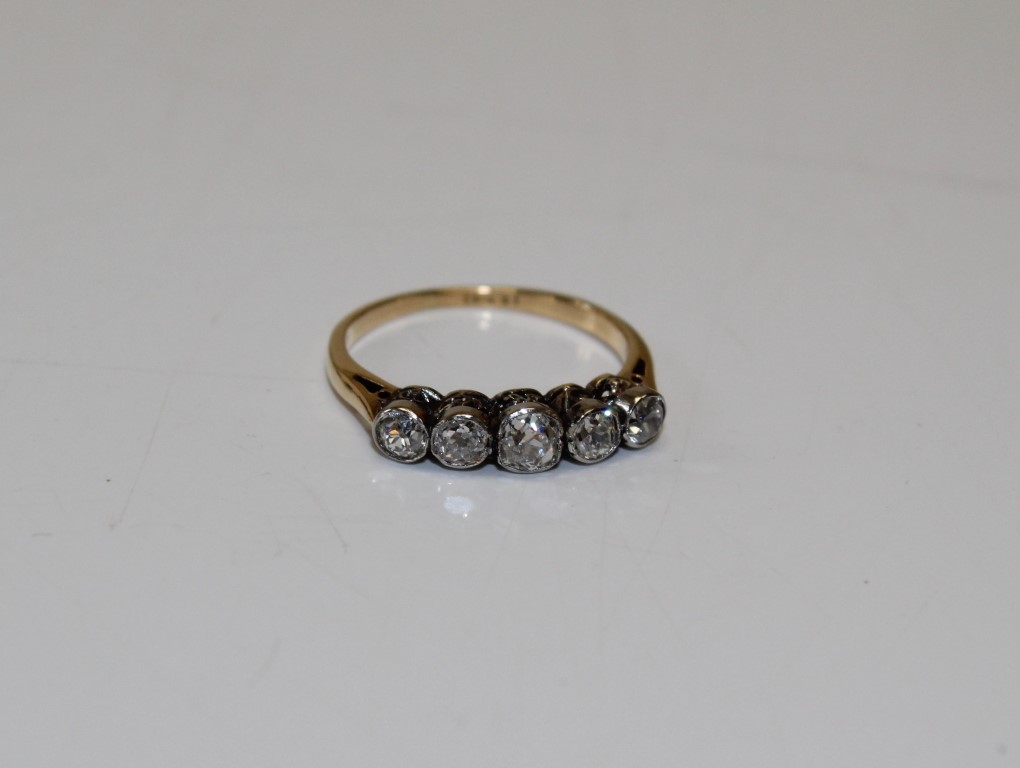 An early 20th century five stone diamond half hoop ring. Stamped "18ct" to the shank and testing