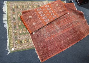 Two 20th century Bokhara wool rugs, each woven with two rows of guls, on a rust ground, 190 x