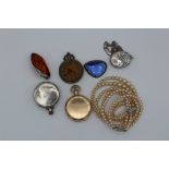 A collection of silver and costume jewellery. Comprising an aesthetic movement locket, an Amber
