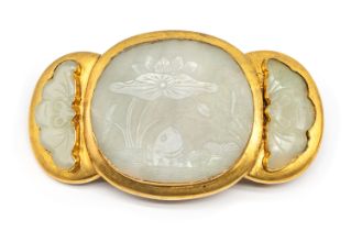 An Asian carved jadeite gilt belt buckle, comprising a central oval cased jadeite, with lily pad and