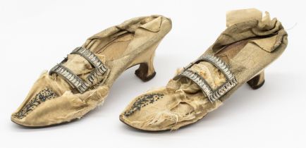 A pair of mid to late 18th century silk shoes, in cream silk, with grey embroidered/floral motifs to