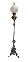 A late 19th/early 20th century tall brass standing oil lamp, having ornate base modelled as a closed